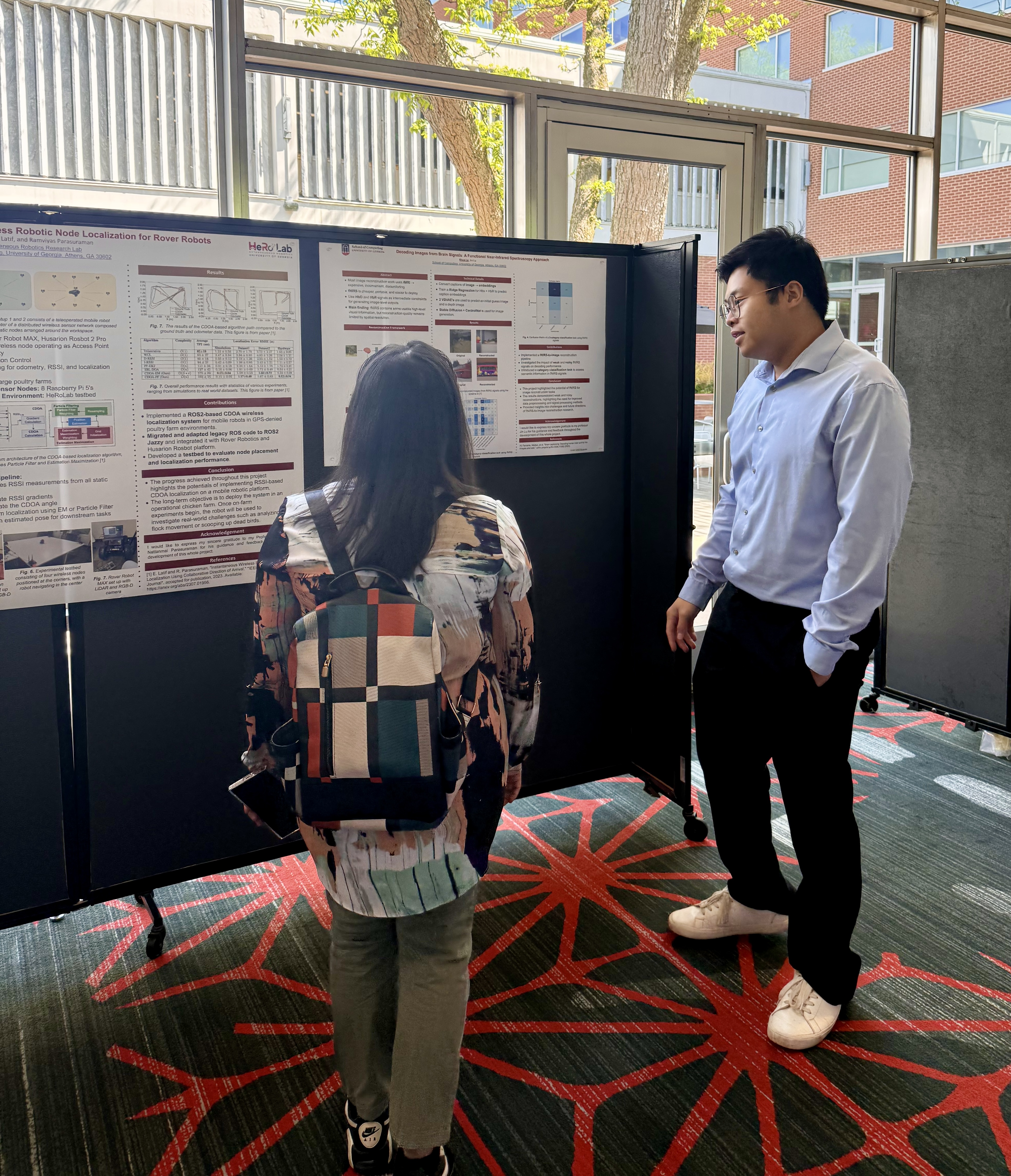 two students talking in front of poster 