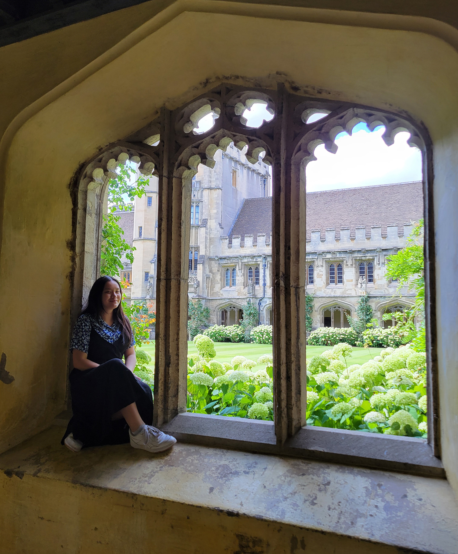 photo of woman seated in triple window frame