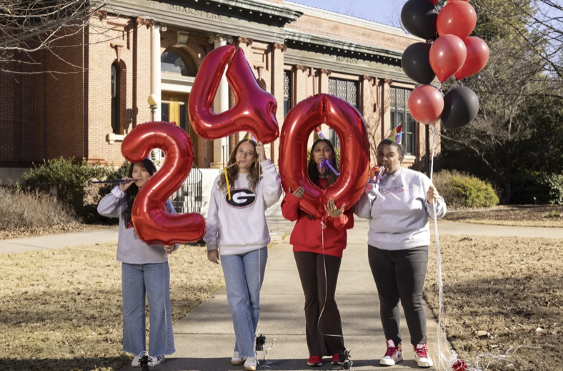 photo of students holding inflatable numbers, balloons, day
