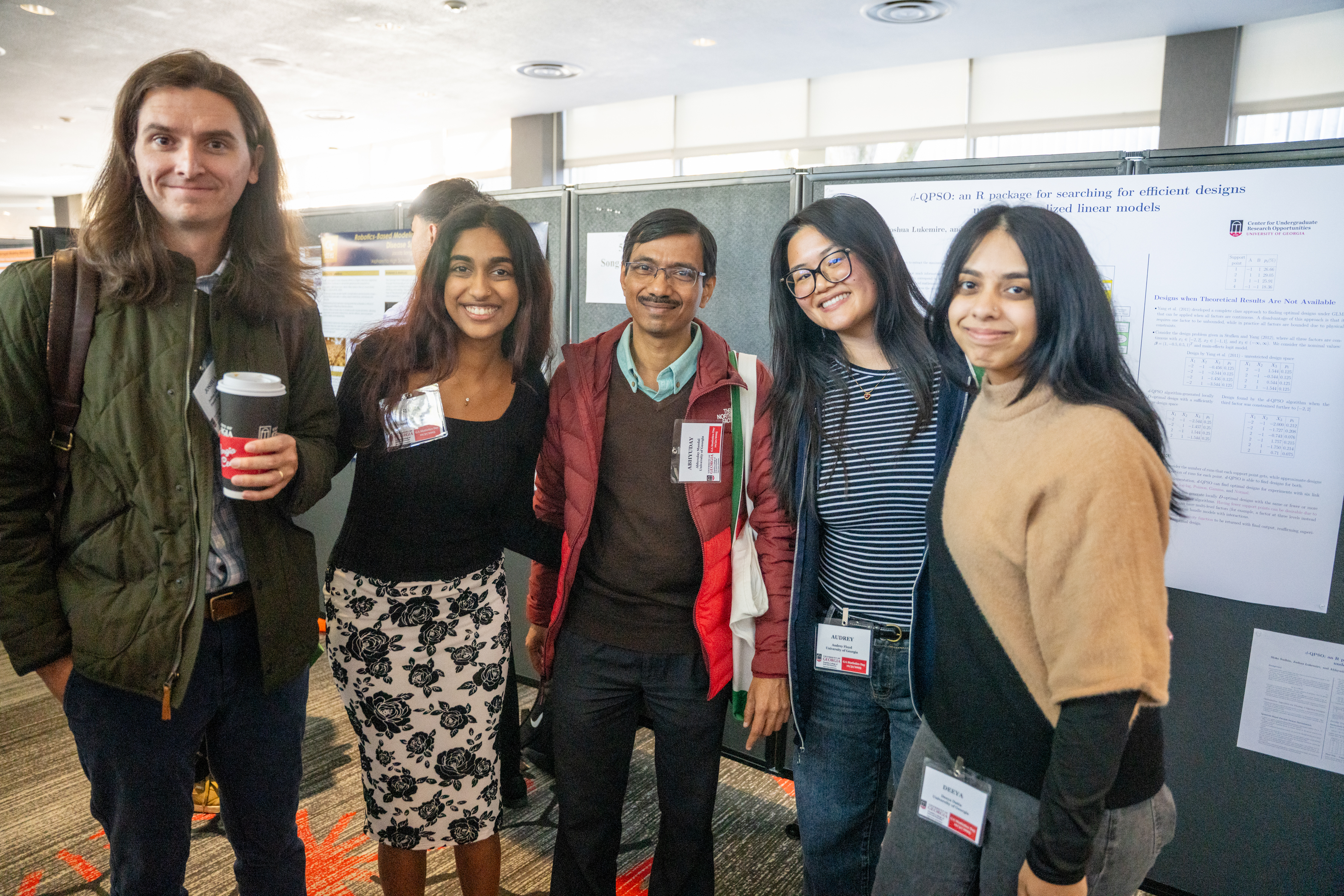 photo of five people, poster in background