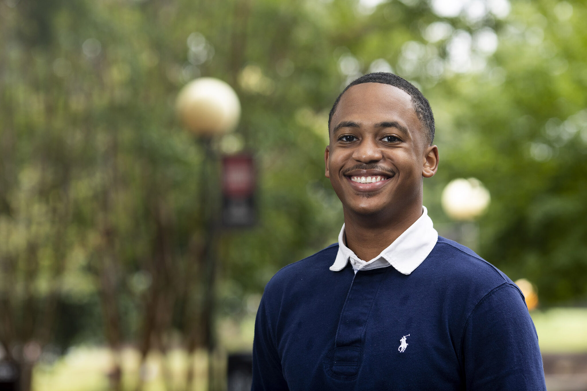 Photo of man in blue shirt outdoors, day
