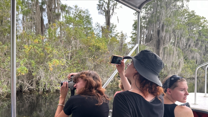 photo of people on boat in swamp