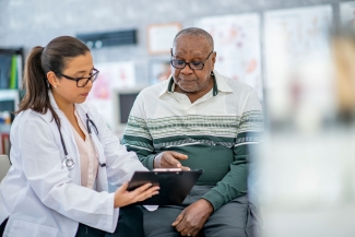 photo of doctor with patient, both looking at clipboard
