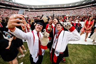 photo of people taking selfies in stadium, crowd in background