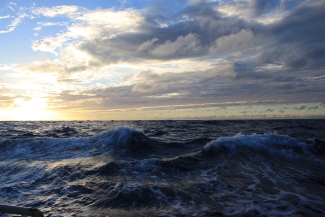 photo of breaking waves in ocean with clouds and sky