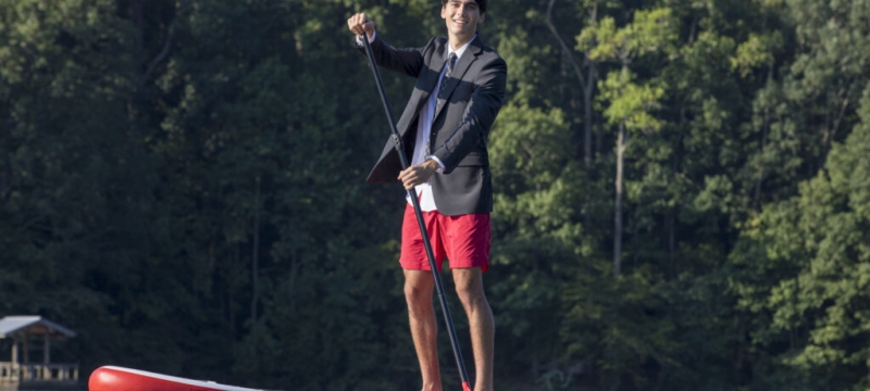 photo of man in coat and tie on lake
