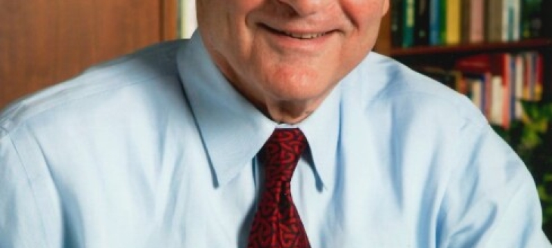 photo of man, bookshelves in background