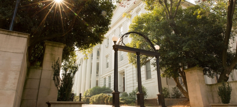 photo of arch, trees, building in background, day