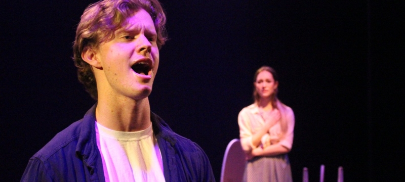 photo of three people, man in foreground singing