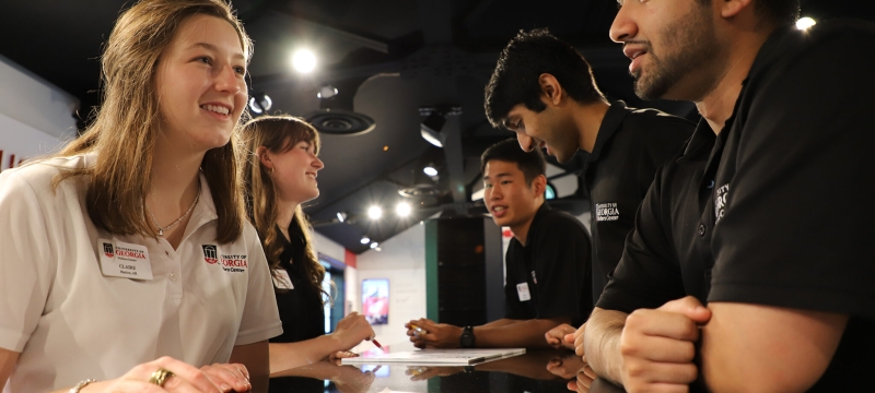 photo of people talking cross desk