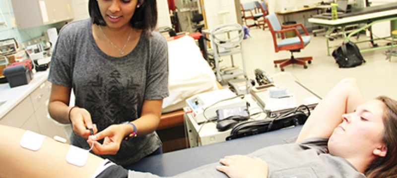 Photo one woman treating another in a lab