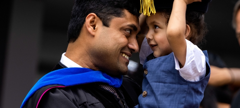 photo of man and child with cap and gown