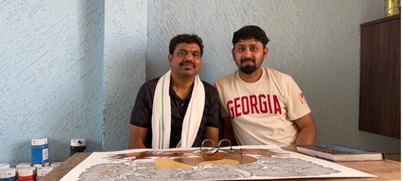 photo of two men, with drawing on table