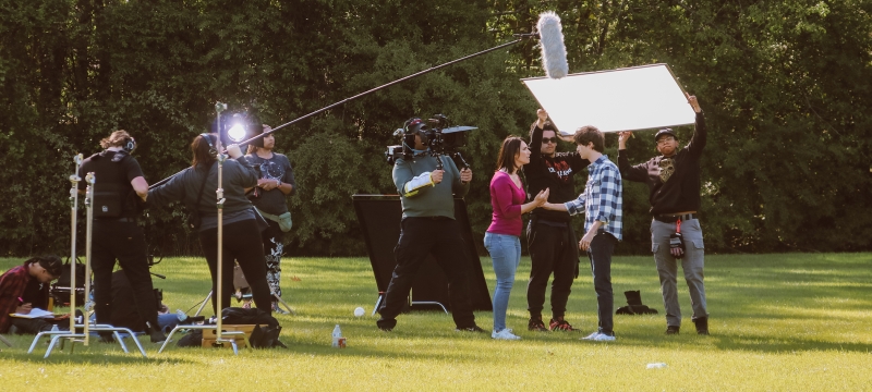 photo of people working on film set, outdoors, day