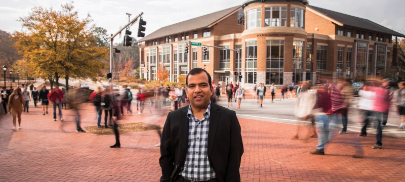 Photo of man with blurred crowds, street, in background