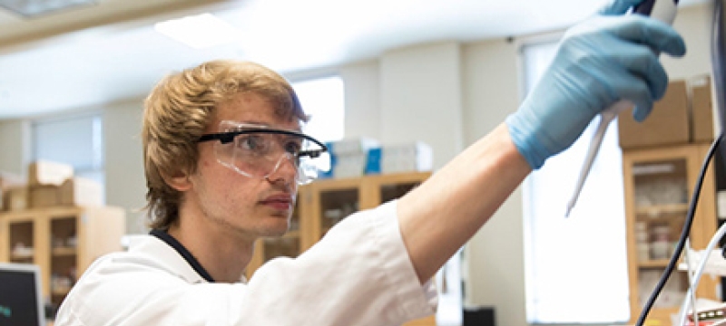 photo of young man in lab with goggles