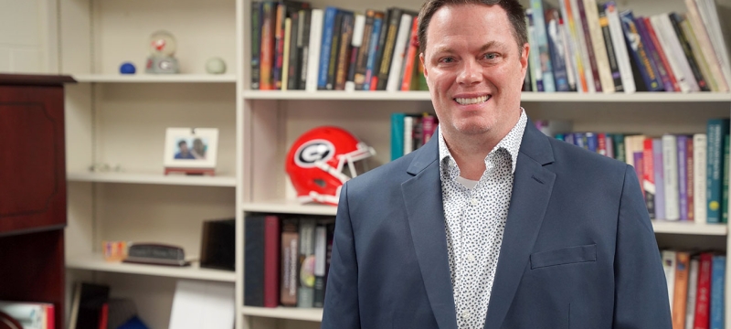 photo of man, bookshelves background