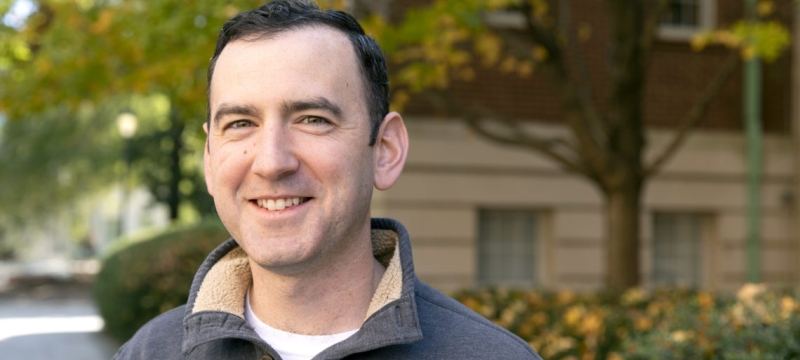photo of man outside, with building, day