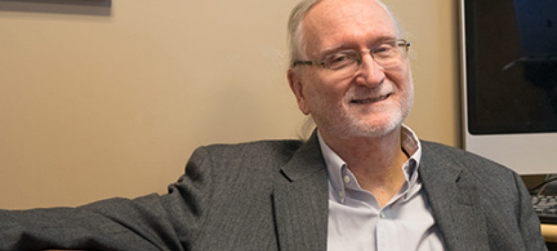 photo of man, seated with monitor
