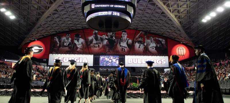 photo of people in caps and gowns inside the coliseum