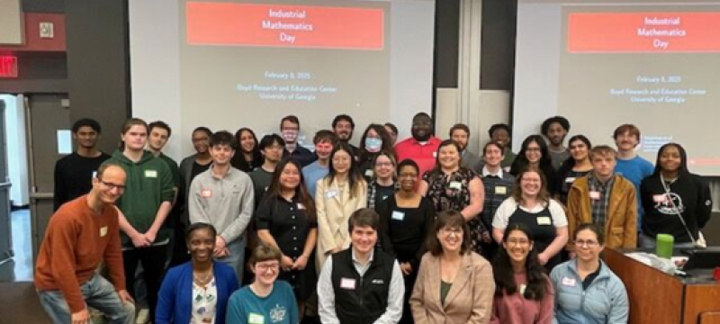 group photo of people, screen in background