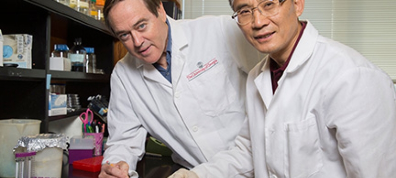two men in a lab with white coats