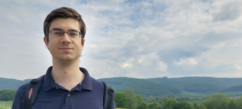 photo of man, field of yellow flowers in background