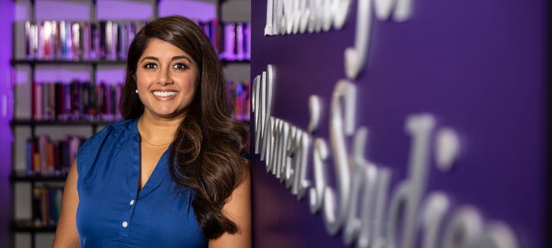 photo of woman and sign, books in background