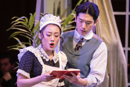 photo of man and woman holding book, woman singing