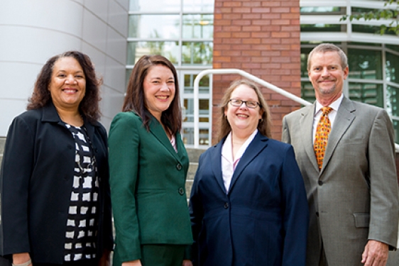 Four people in front of the Rusk center