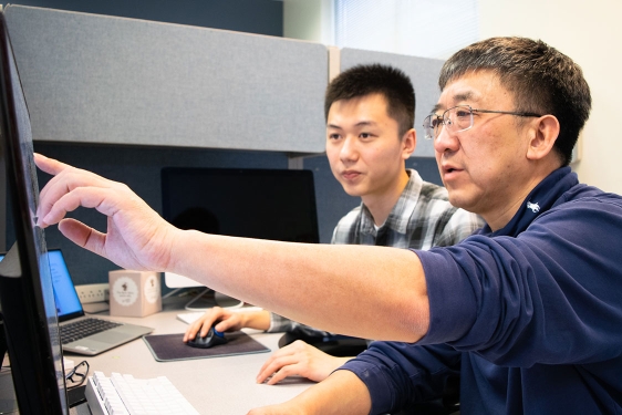 photo of two men at a computer screen